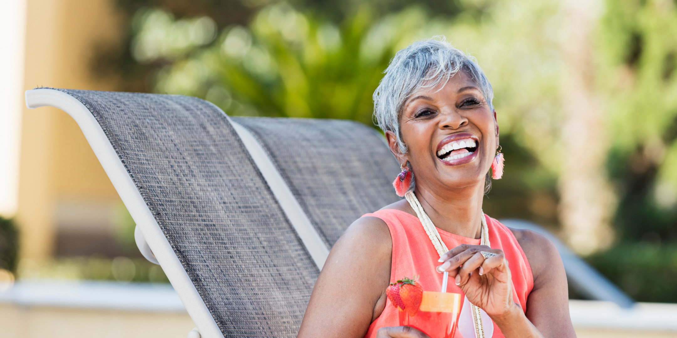 Older woman holding a drink and smiling